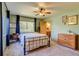 Cozy bedroom with a vintage-style bed frame, large window, and a glimpse into the ensuite bathroom at 3010 Zinnia Ct, Golden, CO 80401