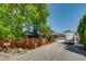 Inviting home exterior with mature trees and a stylish wooden fence, showcasing the property's charm at 3010 Zinnia Ct, Golden, CO 80401
