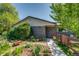 Front yard featuring garden, lawn, and walkway leading to the gray brick ranch-style home at 3010 Zinnia Ct, Golden, CO 80401