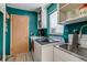 Functional laundry room with stainless steel sink, teal walls and built in storage at 3010 Zinnia Ct, Golden, CO 80401