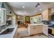 Open kitchen and living area featuring a stone fireplace and wood beam at 3010 Zinnia Ct, Golden, CO 80401