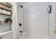 Bathroom with white subway tile, bathtub, shower, and rustic wood shelving at 690 Howe Ct, Castle Rock, CO 80104