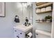 Charming bathroom featuring a gray vanity, a stylish black faucet, and modern shelving with storage at 690 Howe Ct, Castle Rock, CO 80104