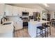 Bright kitchen with stainless steel appliances, white cabinets, subway tile backsplash and center island with bar seating at 690 Howe Ct, Castle Rock, CO 80104