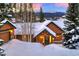 Mountain home with snowy roof and warm lighting at dusk at 699 Highlands Dr, Breckenridge, CO 80424