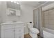Clean bathroom with a vanity, mirror, toilet, and tiled shower with curtain at 6420 S Dayton St # J07, Englewood, CO 80111