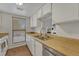 Well-lit kitchen featuring a double sink, wood countertops, and a convenient pass-through window at 6420 S Dayton St # J07, Englewood, CO 80111