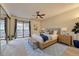 Spacious main bedroom with a ceiling fan, balcony access, and contemporary furnishings at 6420 S Dayton St # J07, Englewood, CO 80111