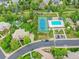 Aerial view of a luxury home with a tennis court, swimming pool and lush landscaping at 291 Fairchild Dr, Highlands Ranch, CO 80126