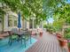 Outdoor dining on a spacious deck with lush greenery and shade from mature trees at 291 Fairchild Dr, Highlands Ranch, CO 80126
