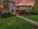 Elegant two-story home with landscaped yard, stone chimney, and a beautiful entrance enhanced by the sunset at 291 Fairchild Dr, Highlands Ranch, CO 80126