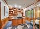 Stylish office with custom wood bookshelves, wainscoting, an area rug, and a large window with shutters at 291 Fairchild Dr, Highlands Ranch, CO 80126