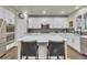 Modern kitchen featuring white cabinets, stainless steel appliances, and a spacious center island at 3762 White Rose Loop, Castle Rock, CO 80108