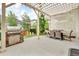 Stylish outdoor patio featuring a stone grill, dining table, and comfortable seating area under a pergola at 3762 White Rose Loop, Castle Rock, CO 80108