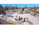 Aerial view of a expansive snow-covered backyard with playground and seating at 6943 Saddleback Ave, Firestone, CO 80504