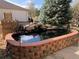 Landscaped backyard featuring a serene pond at 6943 Saddleback Ave, Firestone, CO 80504