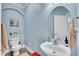 Cozy half bathroom features a blue walls, modern fixtures, and a decorative mirror at 6943 Saddleback Ave, Firestone, CO 80504