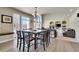 Bright dining room features a large window, modern chandelier, and fireplace with built-in shelving at 6943 Saddleback Ave, Firestone, CO 80504