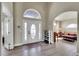 Inviting foyer showcasing a decorative glass front door, high ceilings, and seamless flow into the living area at 6943 Saddleback Ave, Firestone, CO 80504