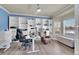 Bright home office with built-in shelving, ample workspace, and a comfortable seating area for productivity at 6943 Saddleback Ave, Firestone, CO 80504