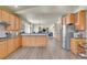 Open-concept kitchen with wood cabinets, stainless steel appliances, and seamless transition to the living area at 6943 Saddleback Ave, Firestone, CO 80504