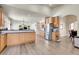 Bright kitchen features wood cabinets, stainless steel appliances, tile backsplash, and hardwood floors at 6943 Saddleback Ave, Firestone, CO 80504