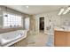 Luxurious main bathroom with a soaking tub, glass shower, double sinks, and walk-in closet at 6943 Saddleback Ave, Firestone, CO 80504
