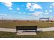A community park featuring a grassy area, bench, and picnic tables under a pergola against a bright blue sky at 2214 Alyssa St, Fort Lupton, CO 80621
