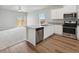 Open concept kitchen features stainless appliances, island, granite countertops and wood flooring at 2214 Alyssa St, Fort Lupton, CO 80621