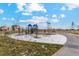 Community playground surrounded by a lush green space and a sidewalk at 2214 Alyssa St, Fort Lupton, CO 80621