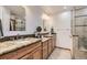 Bright bathroom features dual vanities with granite countertops and a tiled walk-in shower at 2066 E 129Th Ave, Thornton, CO 80241