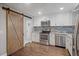 Modern kitchen with stainless steel appliances and barn door at 3608 N Grape St, Denver, CO 80207