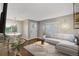 Virtually staged living room with L-shaped sofa and adjacent dining area at 3608 N Grape St, Denver, CO 80207