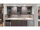 Modern basement bar with granite countertop,wine fridge, and geometric tile backsplash at 5831 S Albion Ct, Greenwood Village, CO 80121