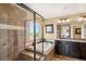 Luxurious bathroom featuring soaking tub, glass shower, and vanity with granite counter at 22268 E Hidden Trail Dr, Parker, CO 80138
