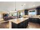 Modern kitchen featuring a large island, dark wood floors, and seamless connection to living spaces at 22268 E Hidden Trail Dr, Parker, CO 80138