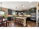 Open kitchen featuring dark cabinets, granite countertops, and a large island with seating at 22268 E Hidden Trail Dr, Parker, CO 80138