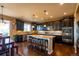 Well-appointed kitchen features dark wood cabinets, granite countertops, and a center island with barstools at 22268 E Hidden Trail Dr, Parker, CO 80138