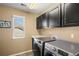 Bright laundry room features modern appliances and ample storage with dark cabinetry and a window at 22268 E Hidden Trail Dr, Parker, CO 80138