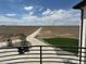 View of backyard from balcony with motorcycle and driveway, showcasing outdoor potential and scenic surroundings at 13350 Imboden Rd, Hudson, CO 80642