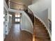 Grand foyer with hardwood floors, staircase, iron railing, and open floor plan with lots of light at 13350 Imboden Rd, Hudson, CO 80642