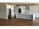 Spacious kitchen featuring white cabinetry, stainless steel appliances, large marble island, and hardwood flooring at 13350 Imboden Rd, Hudson, CO 80642