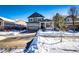 Two-story house with gray siding, attached garage, and snowy front yard at 5808 S Duquesne Ct, Aurora, CO 80016