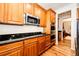 Kitchen with wood cabinets, granite countertops, and stainless steel appliances at 5808 S Duquesne Ct, Aurora, CO 80016