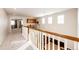 Upstairs hallway with carpet, wooden railing, and views into other rooms at 5808 S Duquesne Ct, Aurora, CO 80016