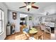 Cozy dining area featuring a wooden table, ceiling fan, and access to the modern kitchen with black cabinets at 7918 S Depew St # D, Littleton, CO 80128