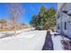 Light blue townhome exterior highlighting large trees, a shoveled walkway, and a welcoming front entrance at 7918 S Depew St # D, Littleton, CO 80128