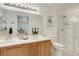 Well-lit bathroom features double sinks, a stand up shower, and a neutral color palette at 8415 Pebble Creek Way # 102, Highlands Ranch, CO 80126