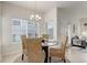 Bright dining space with a glass table, wicker chairs, and seamless flow to the living room at 8415 Pebble Creek Way # 102, Highlands Ranch, CO 80126