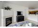 Open-concept layout of the living room with a fireplace and view of the adjacent kitchen at 8415 Pebble Creek Way # 102, Highlands Ranch, CO 80126